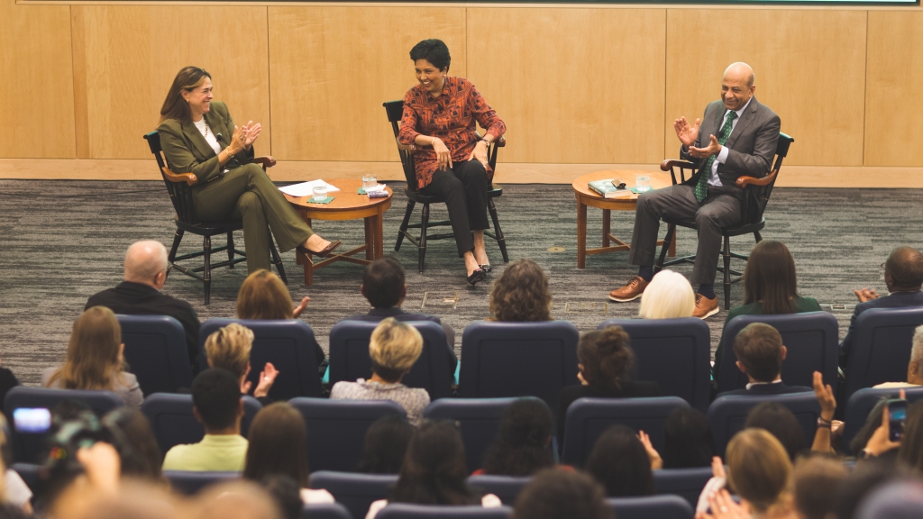 Three people on stage for a talk