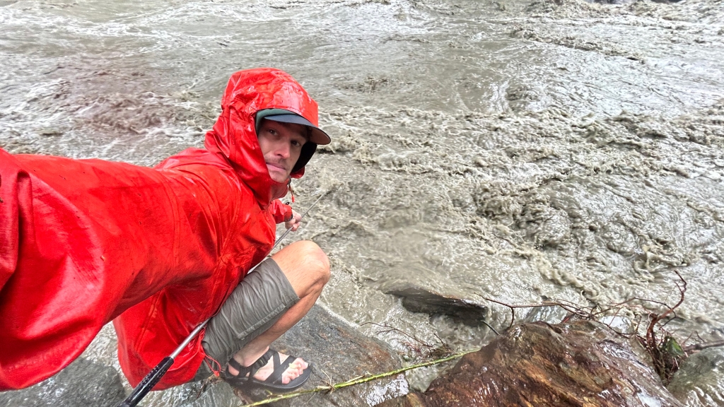 Jordan Fields, Guarini '21, gets sediment sample from flooding brook.