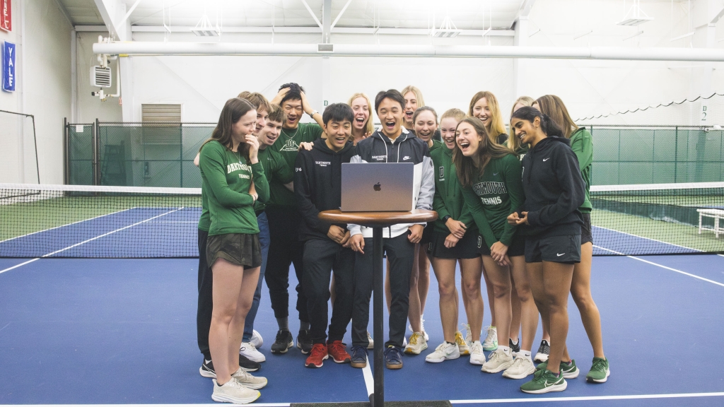 Tennis team around a laptop