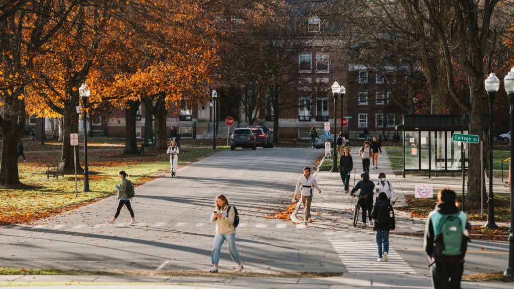 Students walk across campus on a sunny fall day.